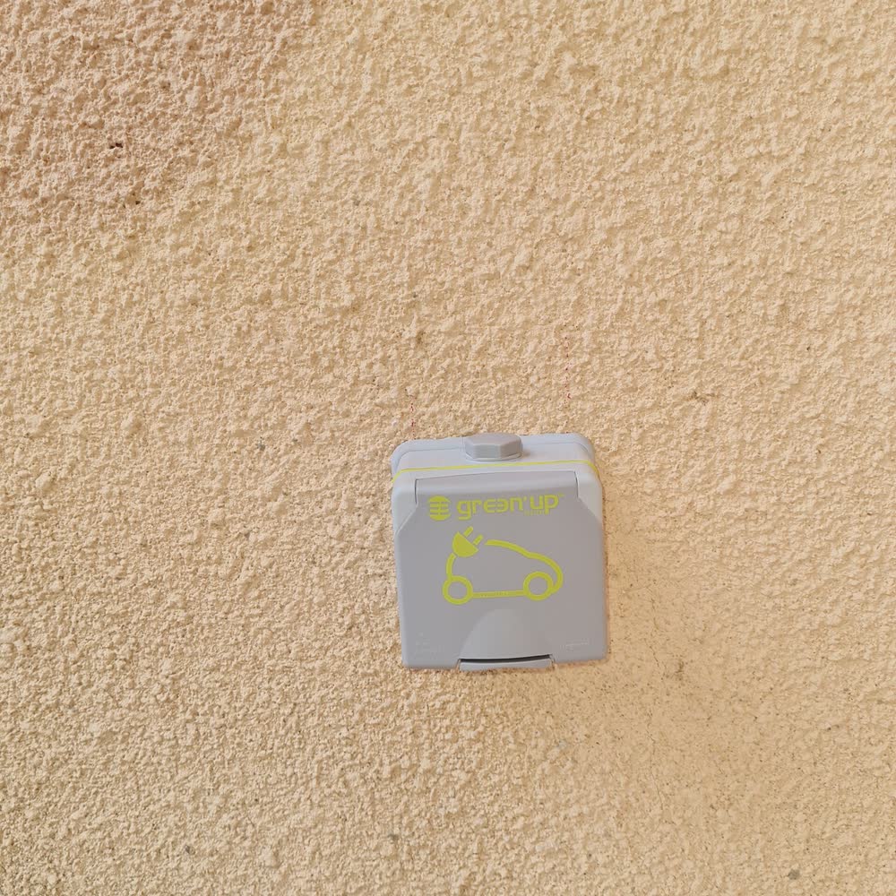 Prise de recharge Green'Up posée par Elec Froid sur un mur extérieur