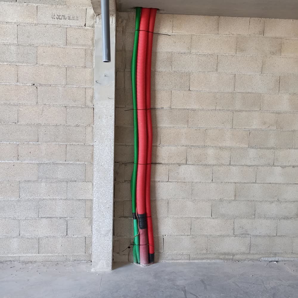 Gaines électriques posées par Elec Froid le long d'un mur en parpaings