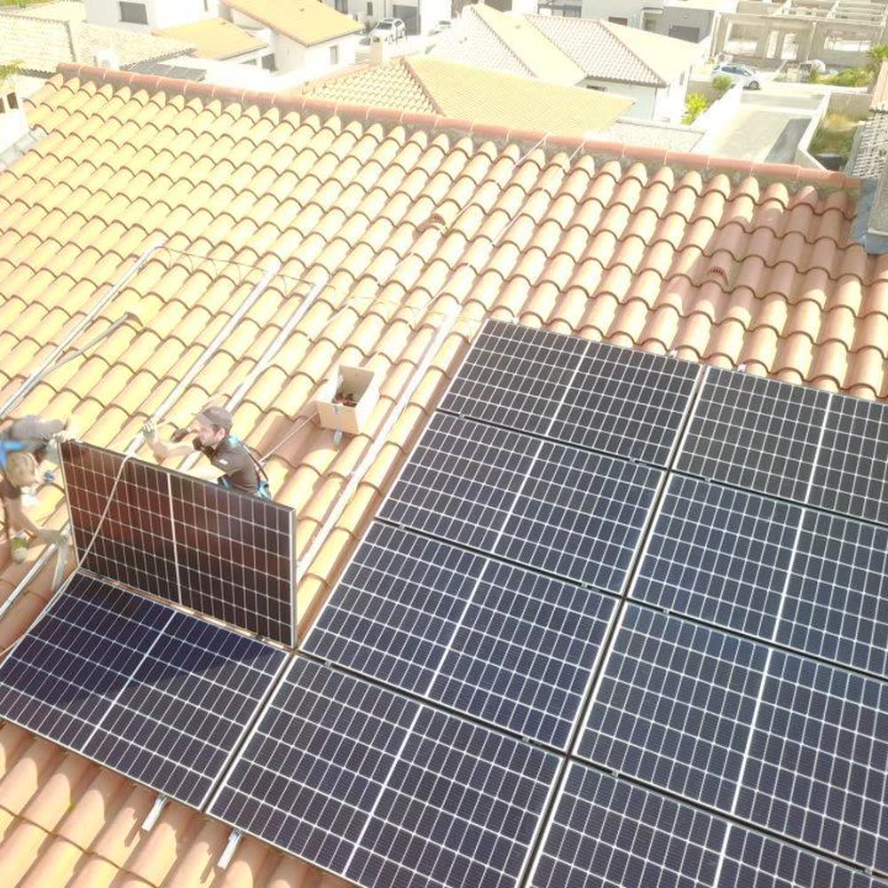 Techniciens Elec Froid posant un panneau sur une toiture déjà équipée